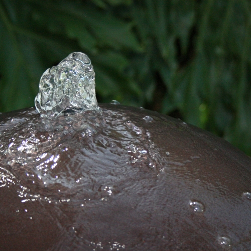 Detalle de chorro de agua brotando de una esfera de fibra de vidrio