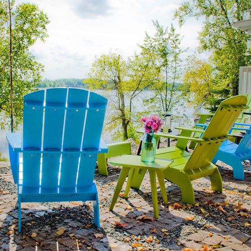 Sillones Adirondack de colores frente a un lago