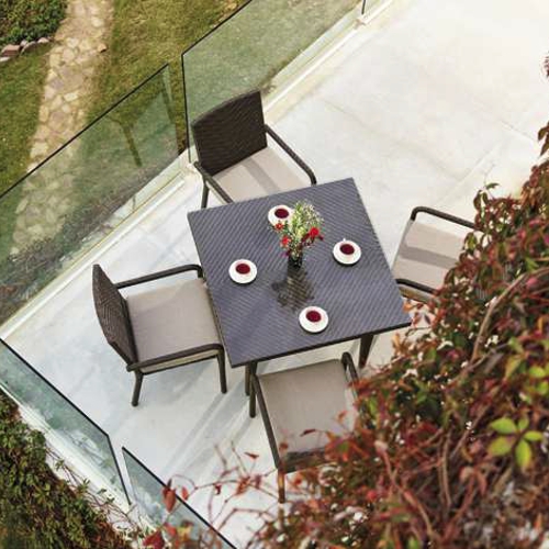 Mesa y sillas tejidas con Viro de la colección Burano en una terraza al exterior