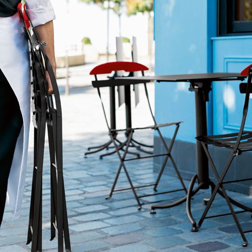 Ejemplo de sillas plegables de acero La Mome en un restaurante al aire libre