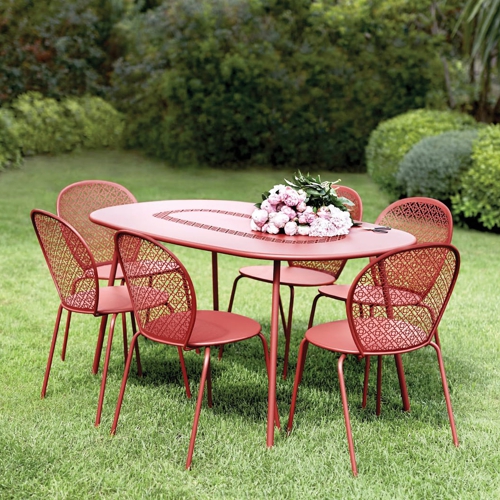 Mesa ovalada Lorette con sus sillas en un jardin a exterior